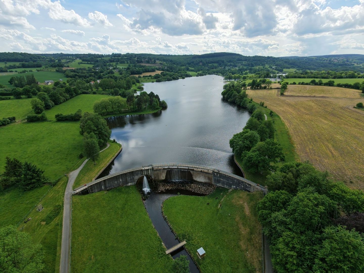 Luchtfoto van een meer met stuwdam in een groen dijklandschap